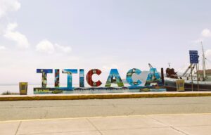 Letrero 'Titicaca, Puno: Aquí nació el Imperio de los Incas' con el lago Titicaca de fondo, un paisaje histórico y cultural en Perú